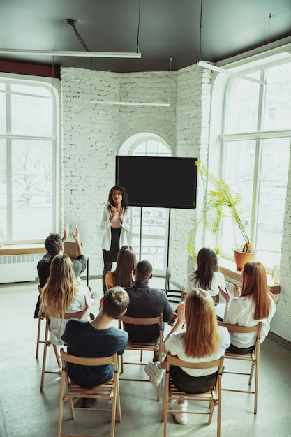 Female african-american speaker giving presentation in hall at university workshop