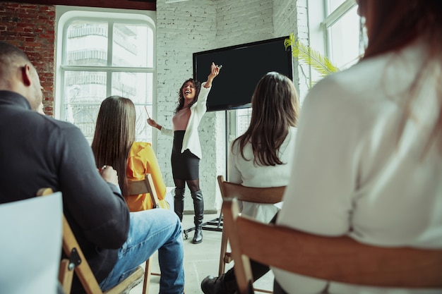 Female african-american speaker giving presentation in hall at university workshop