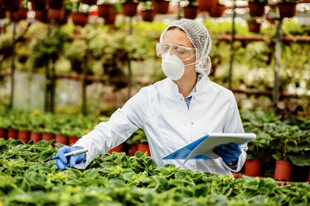 식물 종묘장에서 품질 관리 검사를 하는 여성 농업 기술자