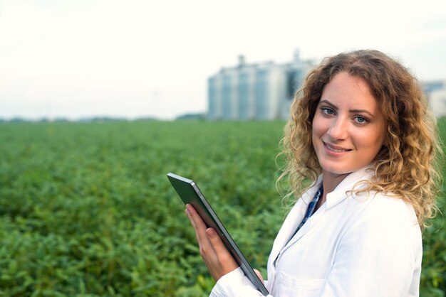 Female agronomist with tablet on field