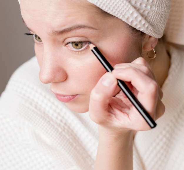 Free photo female applying eyeliner