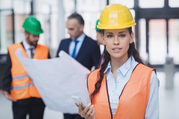 Female architect holding mobile phone