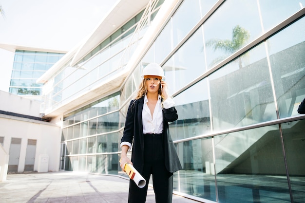 Female architect walking in front of building