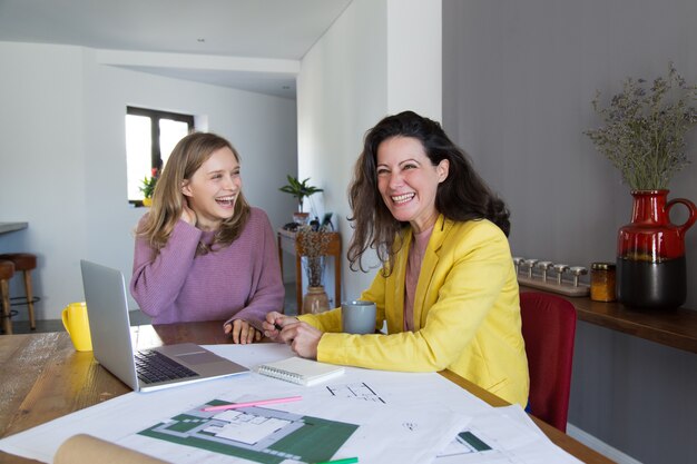 Female architects working with drawings and laughing