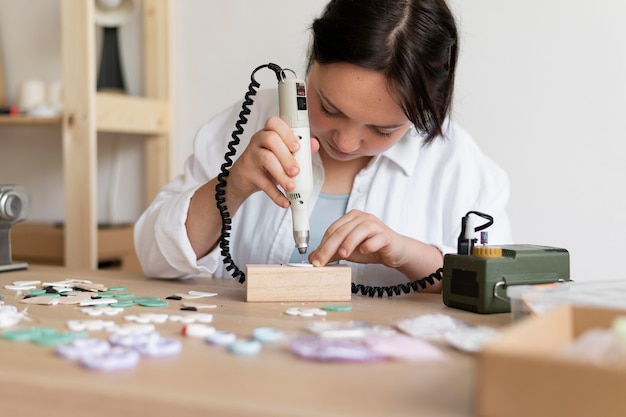 Artigiana che lavora nell'atelier con la pistola per colla