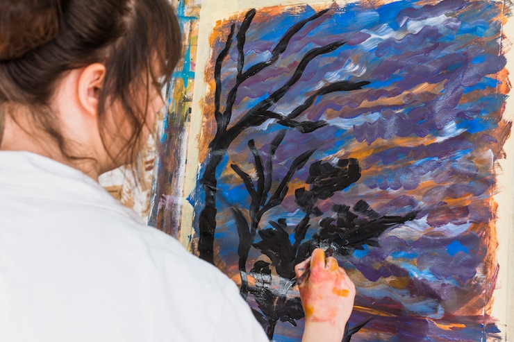 Free Photo female artist drawing on canvas with black brushstroke