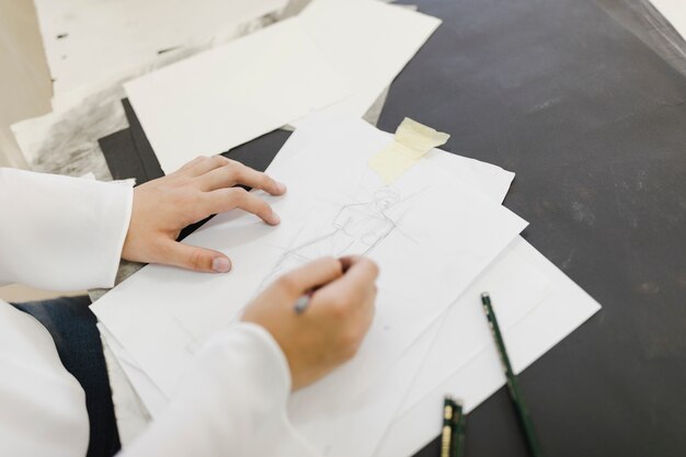 白い紙にスケッチを描く女性アーティスト