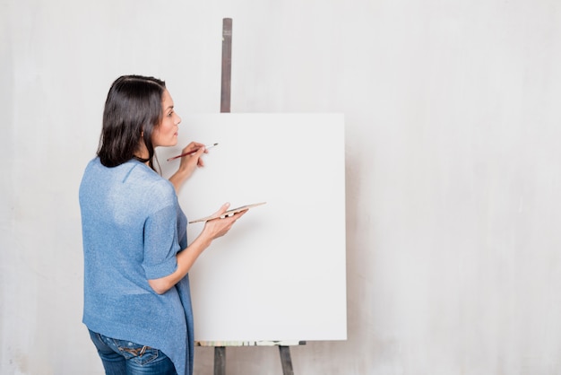 Female artist in front of canvas