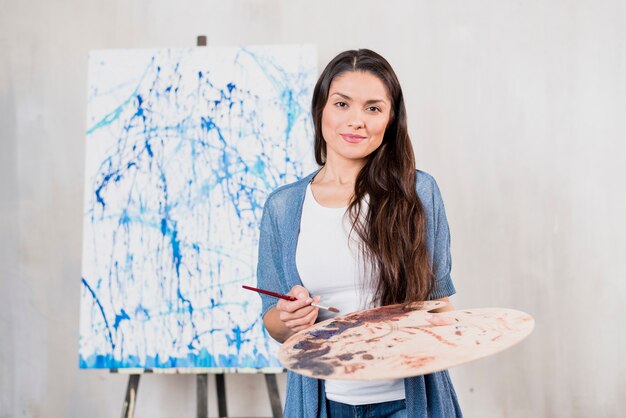 Female artist in front of canvas