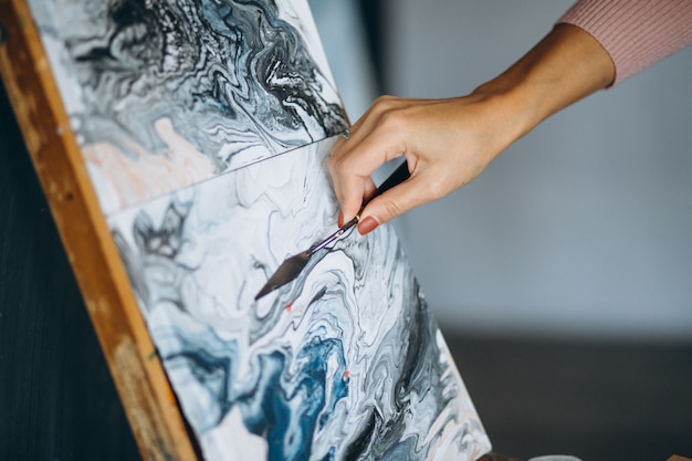 Female artist hands close up using palette knife