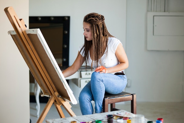 Female artist painting on canvas in studio