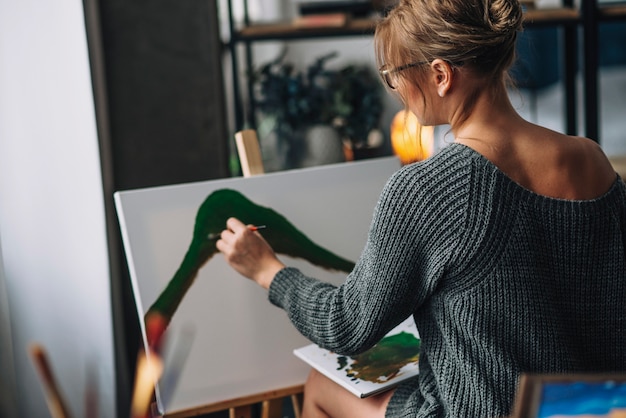 Female artist painting on canvas