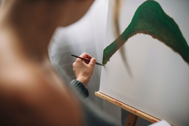 Female artist painting green shape