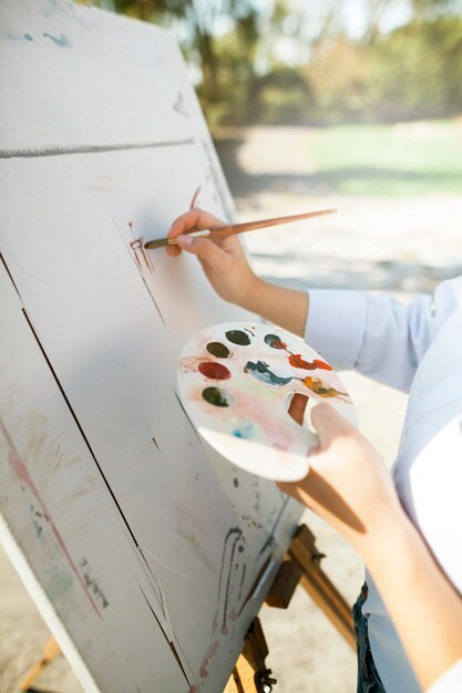 屋外で絵を描く女性アーティスト