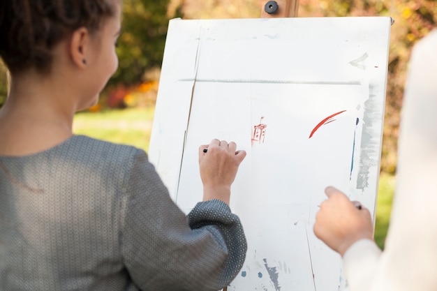 Free photo female artist painting outdoors