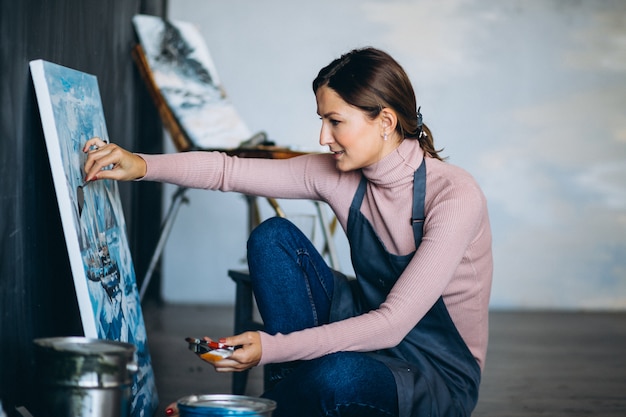 Free photo female artist painting in studio