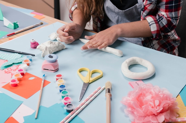 Free photo female artist preparing letter from white clay