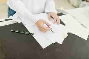 Бесплатное фото Женский художник наброски на белой бумаге с карандашом на столе