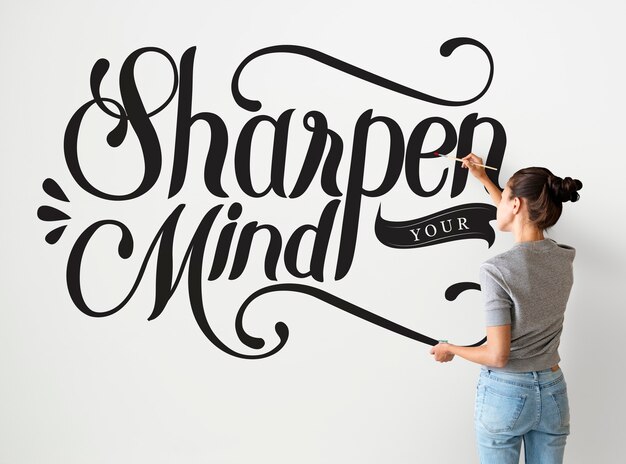 Female artist writing sharpen your mind quote on the wall