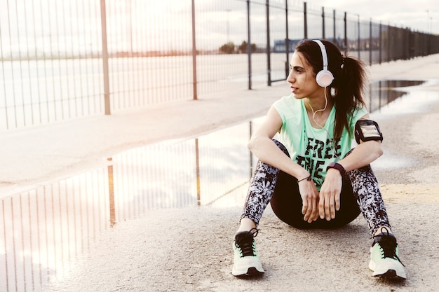 Female athlete listening to music through headphone