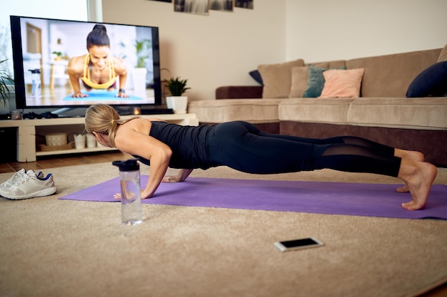 Female athlete practicing pushups during home workout