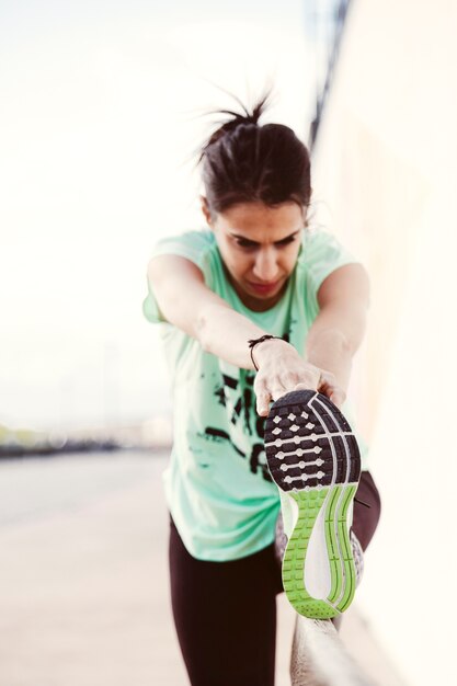 Female athlete stretching her leg outdoors