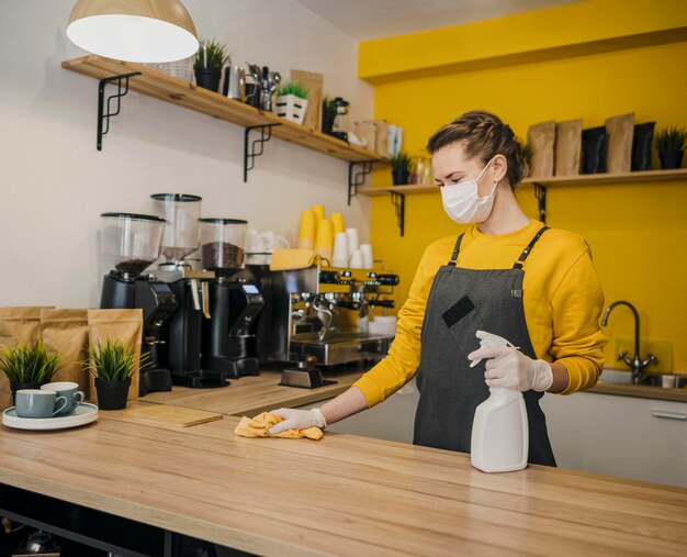 Female barista cleaning surface