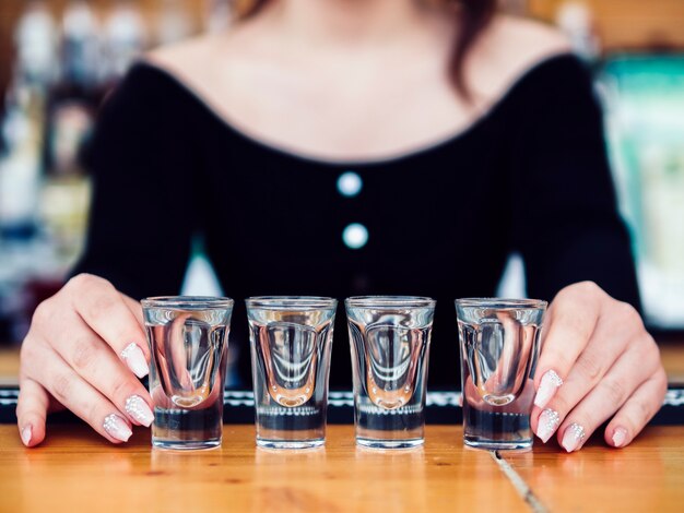 Female bartender with row of shot glasses