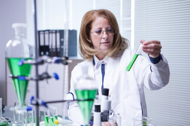 Female biologist wearing a white coat for academic research. Lab for research.