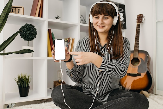 Female blogger streaming with smartphone and headphones at home