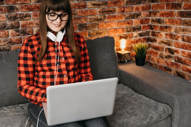 female blogger with headphones streaming online with laptop