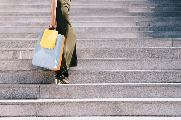 Female body posing on the stairs with bags