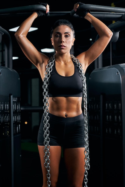 Female bodybuilder posing with chains on neck