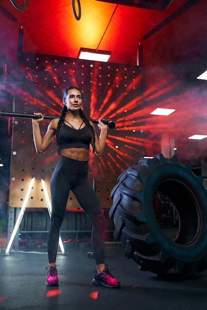 Female bodybuilder posing with sledgehammer