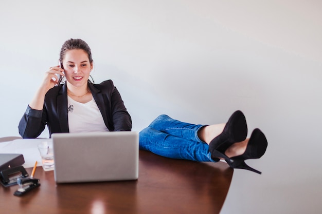 Female boss talking phone in office