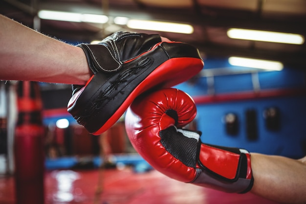 Female boxer practicing with trainer