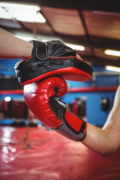 Female boxer practicing with trainer