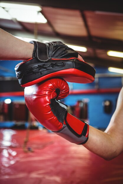 Female boxer practicing with trainer