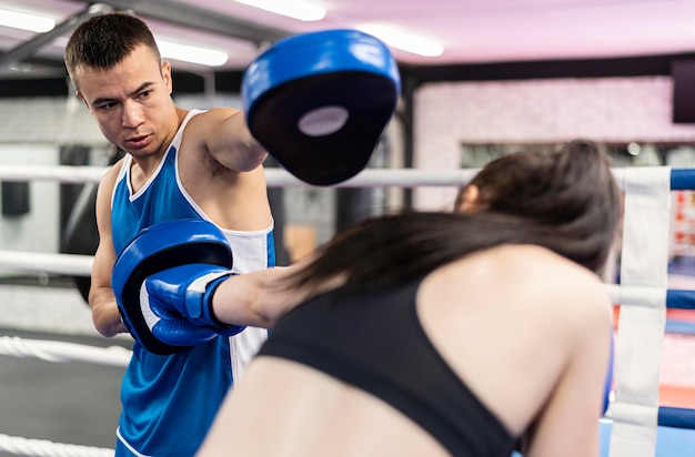 Female boxer practicing with trainer