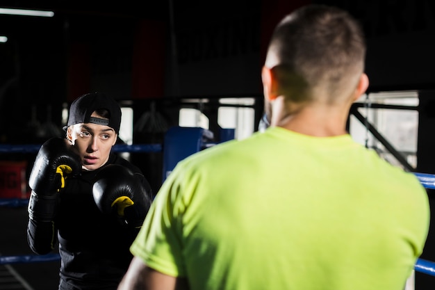 Foto gratuita addestramento femminile del pugile con il pugile maschio sul ring