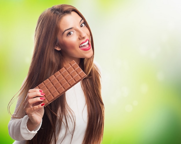 Foto gratuita bruna femminile con la barra di cioccolato