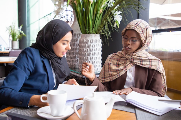 Female business colleagues analyzing and discussing documents