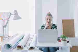 Foto gratuita donna di affari femminile che lavora al computer portatile sul posto di lavoro