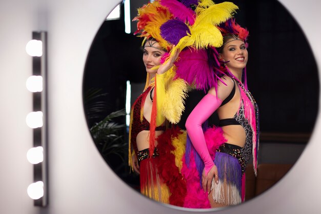 Free photo female cabaret performers posing backstage in feathers costumes