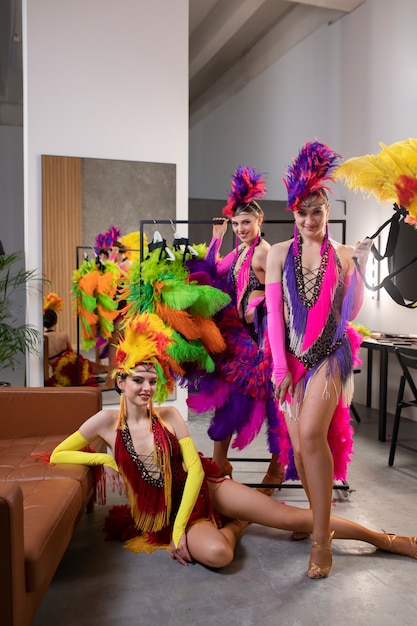 Бесплатное фото Артистки кабаре позируют за кулисами в костюмах из перьев