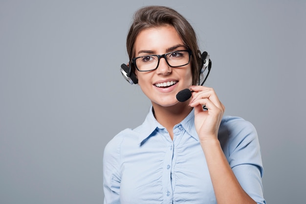 Female call center agent posing with headphones with mic