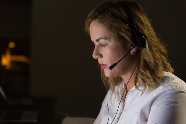 Female call center operator in dark office