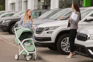 Free photo female car dealer welcoming a buyer