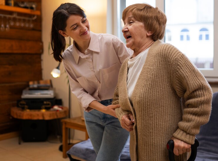 Free Photo female caretaker at her client's house taking care of elderly person