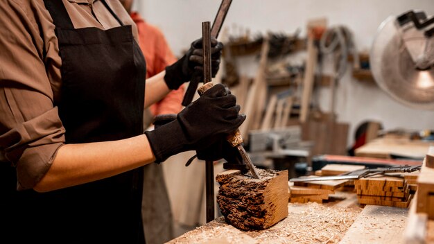 Female carpenter sculpting wood in the studio